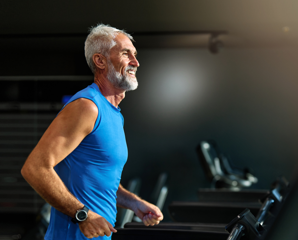 Starszy mężczyzna w dobrej kondycji na bieżni to przykład, że zdrowe starzenie się wspiera holistyczne podejście do zdrowia – regularna aktywność, zdrowe odżywianie, profilaktyka zdrowotna oraz terapie naturalne, w tym suplementacja grzybami prozdrowotnymi, pomagają utrzymać energię i równowagę organizmu.